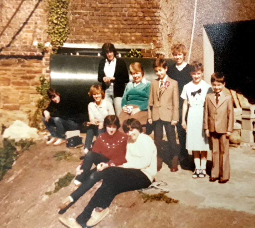 Suzanne and her brothers, Aiden and Declan, with the despatch workers - taken in the back yard of the Mills c. 1983.