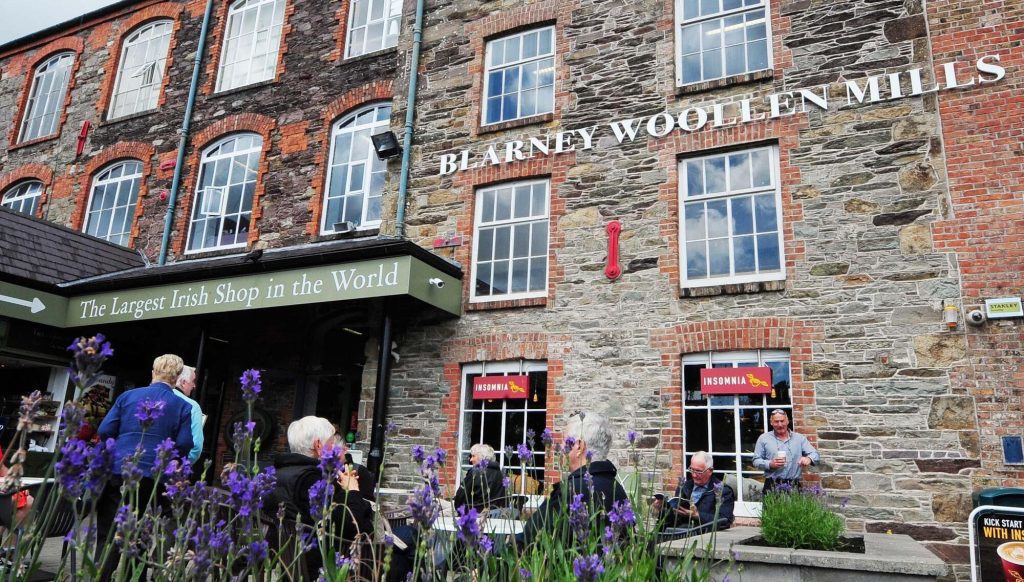 Exterior of Blarney Woollen Mills in County Cork, Ireland, showing the historic stone mill building and visitors outside the largest Irish shop in the world